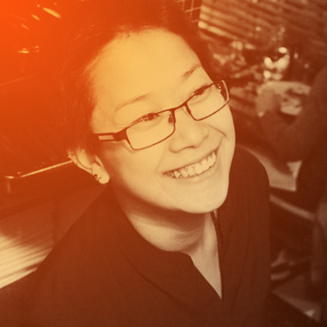 Fai smiling in the middle of a restaurant.